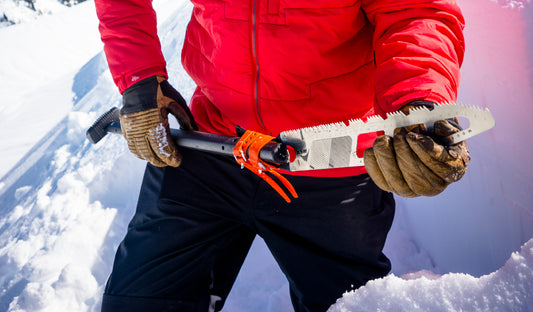 Person holding snow saw while standing in deep snow